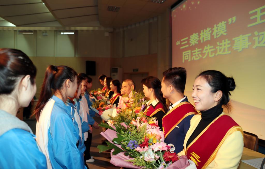 我院学生为报告团成员献花